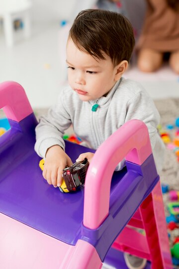 high-angle-toddler-playing-with-toys-slide_23-2148572986